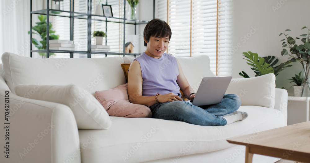 Gen Z queer man non-binary at home. Asia LGBT young guy adult people happy relax sitting at sofa use omni channel easy buy now pay later BNPL shop store. Reading online bank loan news on web page app. Gen Z queer man non-binary at home. Asia LGBT young guy adult people happy relax sitting at sofa use omni channel easy buy now pay later BNPL shop store. Reading online bank loan news on web page app.