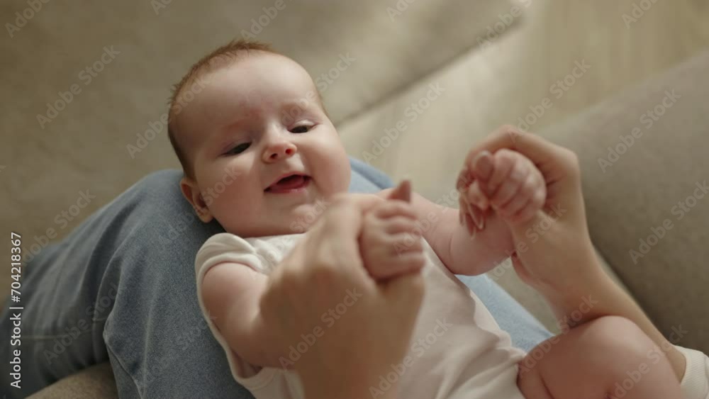 Calm caucasian cute chubby serene newborn baby on mothers knees mother, tenderly touch, celebrating the joy of motherhood and beginning of new life. Maternity and childhood in cinematic advertisement. Calm caucasian cute chubby serene newborn baby on mothers knees mother, tenderly touch, celebrating the joy of motherhood and beginning of new life. Maternity and childhood in cinematic advertisement.