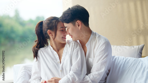 Young adult asia people fiance happy lover flirt fall in love nose lips kiss hug cuddle care trust. Sweet comfort touch newlywed asian couple life man smile look at woman face relax warm time dating.