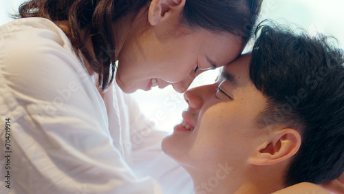 Young adult asia people fiance happy lover flirt fall in love nose lips kiss hug cuddle care trust. Sweet comfort touch newlywed asian couple life man smile look at woman face relax warm time dating. photo