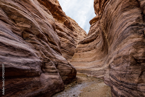 Beautiful  patterns of high mountains on both sides of a shallow stream at the beginning of the Wadi Numeira hiking trail in Jordan photo