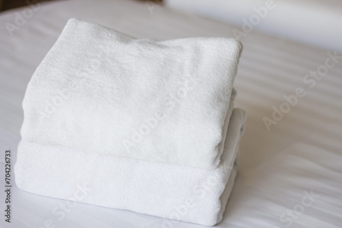 Selective focus on white fresh towels in hotel bed. Room service concept. Closeup white on new bedding and personal hygiene items.
