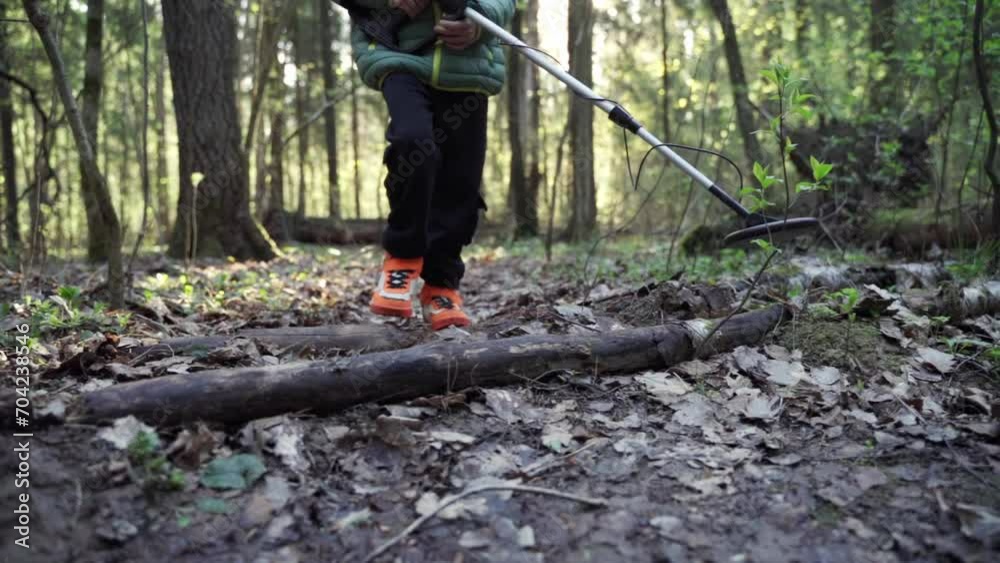 A man is looking for metal with a metal detector. A guy with a metal detector is looking for a treasure against the background of the forest. A man is looking for metal with a metal detector. A guy with a metal detector is looking for a treasure against the background of the forest.