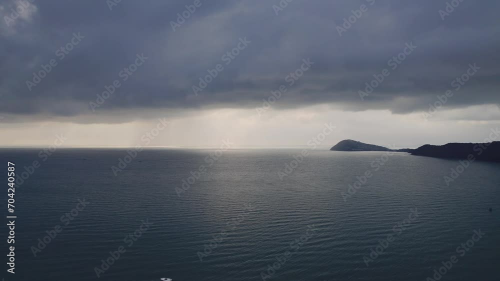 A tranquil seascape with overcast skies, highlighting a beam of sunlight breaking through clouds over calm waters, evoking a peaceful yet moody atmosphere A tranquil seascape with overcast skies, highlighting a beam of sunlight breaking through clouds over calm waters, evoking a peaceful yet moody atmosphere