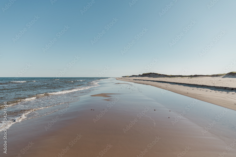 vue sur une longue plage avec le mouvement des vagues avec personne à l'horizon en été lors d'une journée ensoleillée