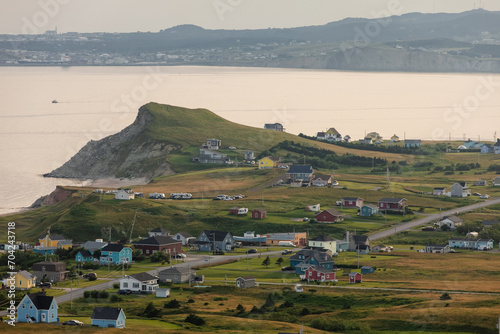 vue sur un village bord de mer avec du gazon vert ainsi que des maisons et une route en été photo