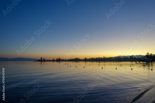 Colorful sunset on the sea. Mountain lake in the rays of the orange sun. Kyrgyzstan  Lake Issyk-Kul. natural background