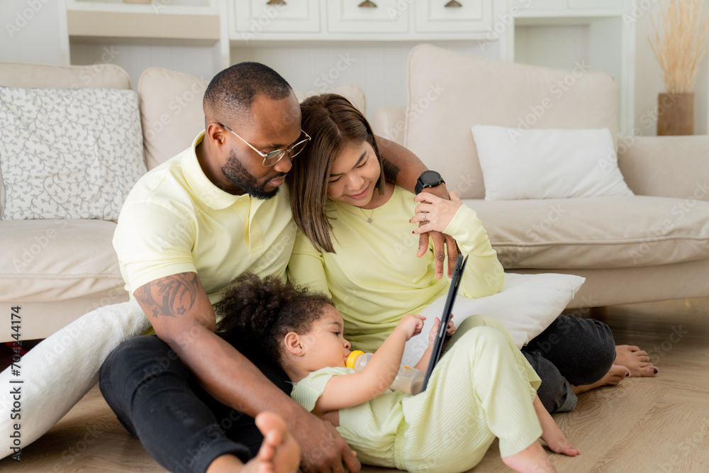 Happy Family Of Three With Little Daughter Having Fun Together At Home, Playing With Their Child In the Living Room, Happy black family Weekend. Happy Family Of Three With Little Daughter Having Fun Together At Home, Playing With Their Child In the Living Room, Happy black family Weekend.