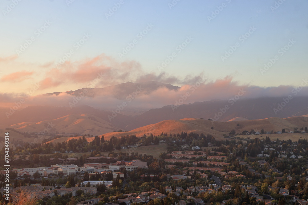 Marine layer low clouds moving over the slopes of Mt Diablo in the East Bay at sunset
