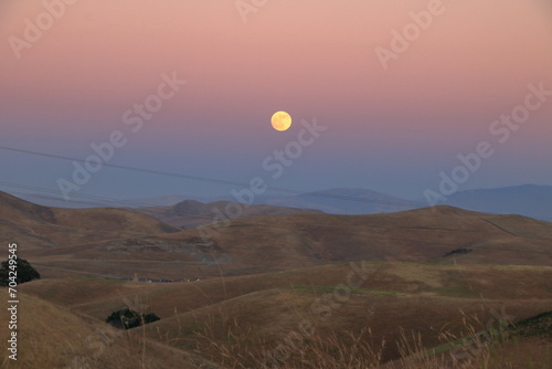 Strawberry Moon rises over the hills in Northern California