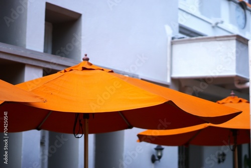 Orange umbrella at an outdoor cafe at summer © Irfan_setiawan