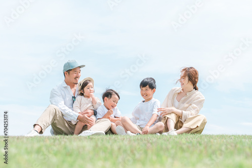 青空の見える公園で遊ぶ家族・ファミリー・親子 