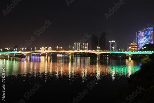 Nanning city,Guangxi province, China at night. Bridge over Yong River with colorful reflection