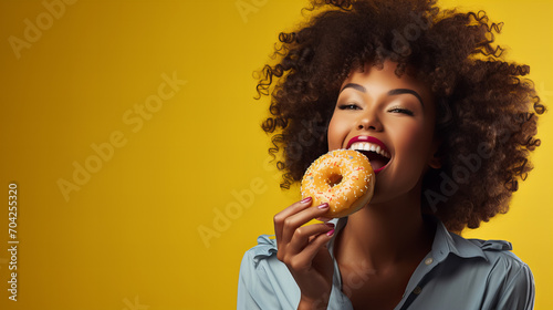 african american woman holding eating donut isolated on yellow background  junk unhealthy food diet concept copy space  Valentine day  sweet tasty life  Valentine day  International Women day