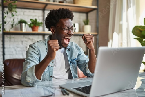 Happy excited African American gen z teen student winner celebrating goal achievement receiving email reading good news about exam results getting scholarship looking at laptop at, Generative AI  photo