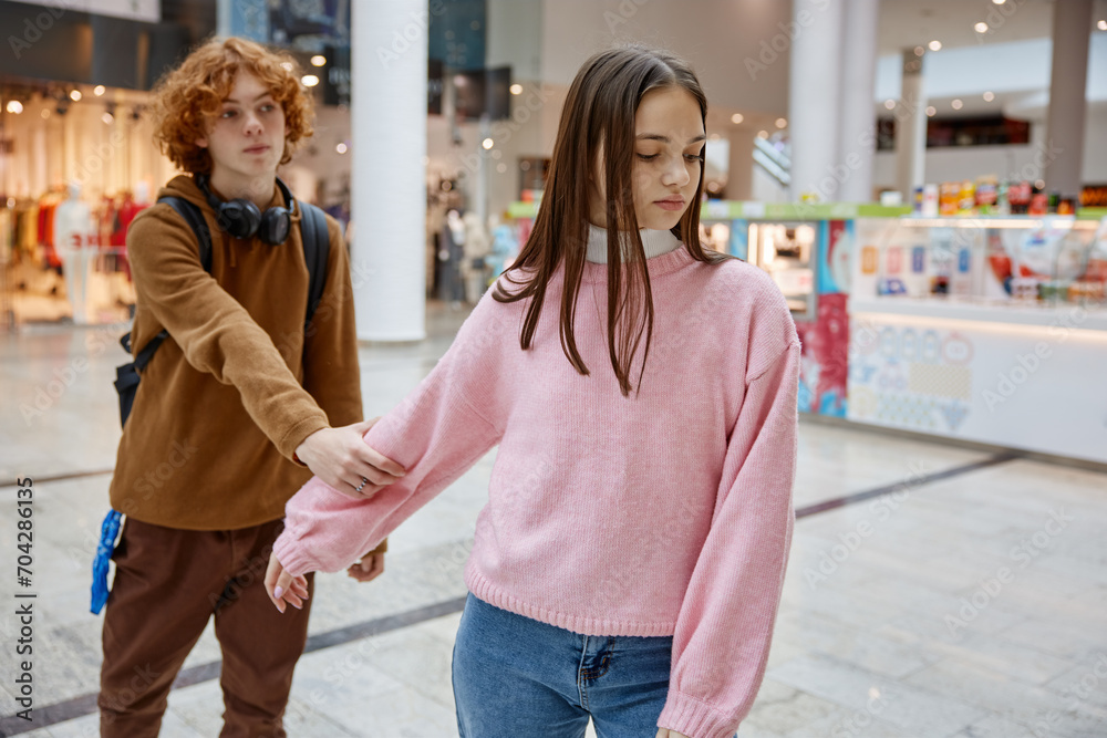 Teenage couple having quarrel during date in shopping center