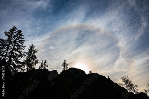 Bright colorful 22 degrees halo around the sun over a mountain