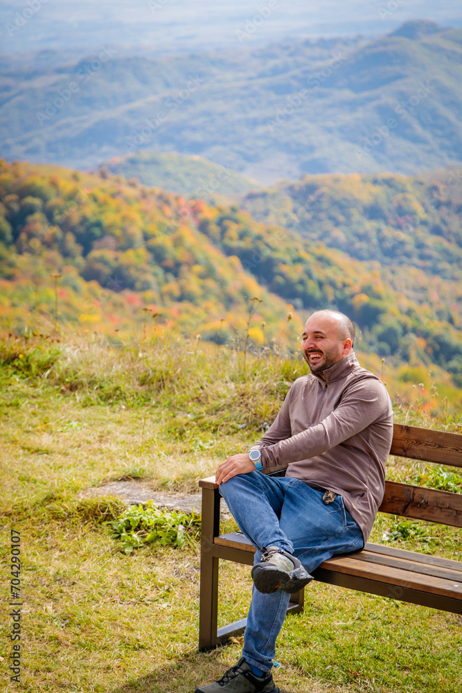 Solitary Figure Absorbing the Stunning Mountain Vista from Secluded Wooden Bench Solitary Figure Absorbing the Stunning Mountain Vista from Secluded Wooden Bench