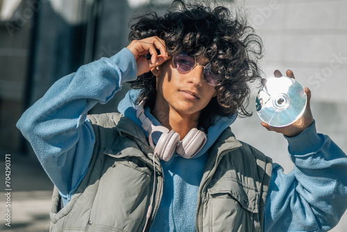 young man with headphones showing CD vintege photo