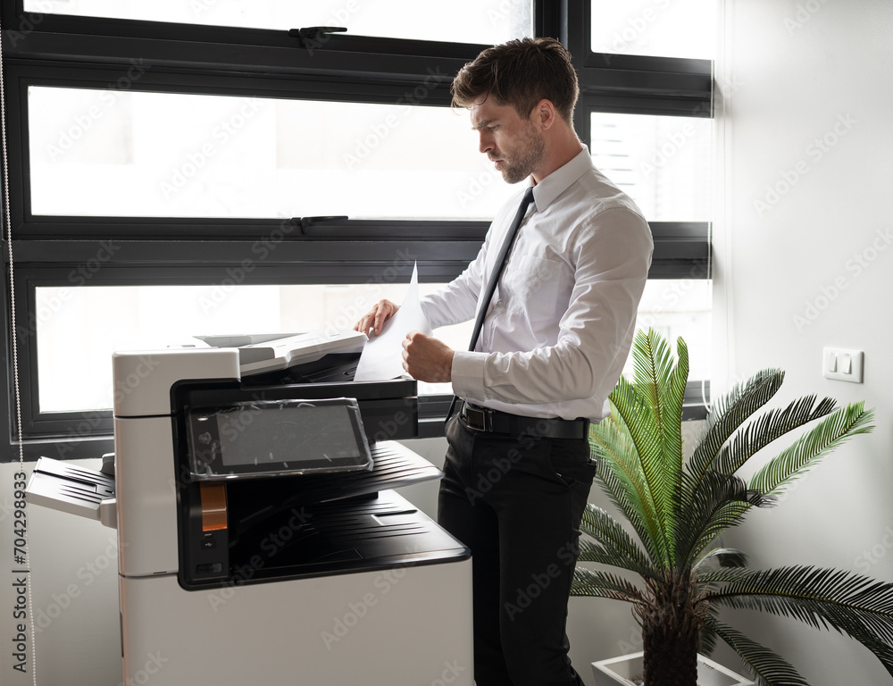 Caucasian businessman working with photocopier at office