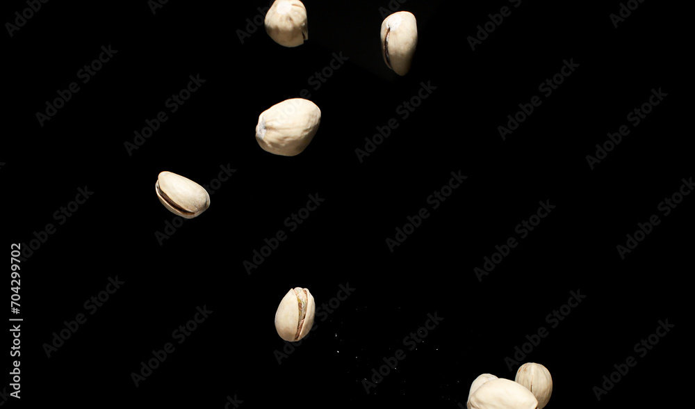 Falling pistachio nuts isolated on black