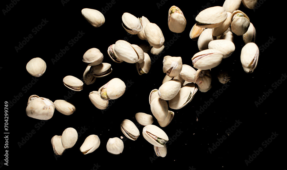 Falling pistachio nuts isolated on black