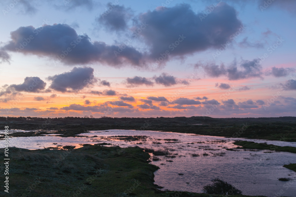 The open expanse of the Grafelijkheidsduinen in Den Helder (Netherlands) is beautifully illuminated by the rising sun, creating a true explosion of colors.