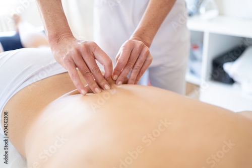 Professional masseuse massaging back of client