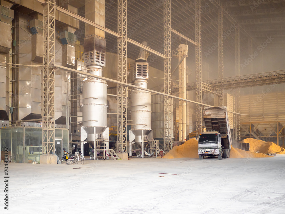 Rice milling factory interior, truck dump rice husk at paddy drying area for dryer to burn.