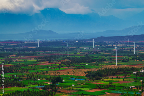 Obraz na płótnie Windmill - Wind turbine installed on the mountain and agriculture land. Arial view of wind trbing farm, Alternate energy source generator with environment friendly. w salonie
