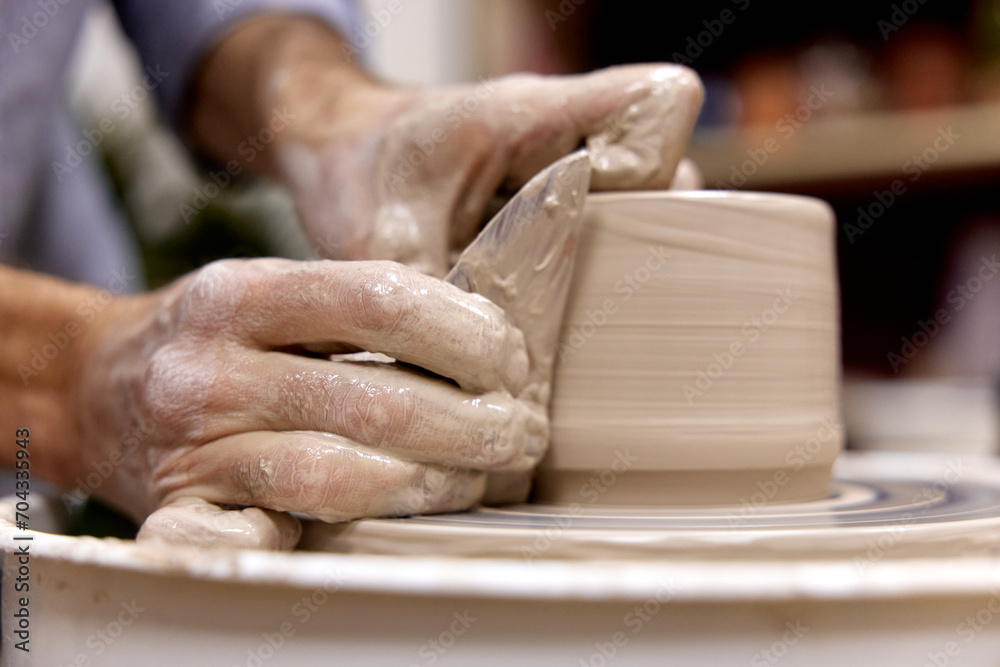 male hands making ceramic cup on pottery wheel with special wooden tool, Close-up