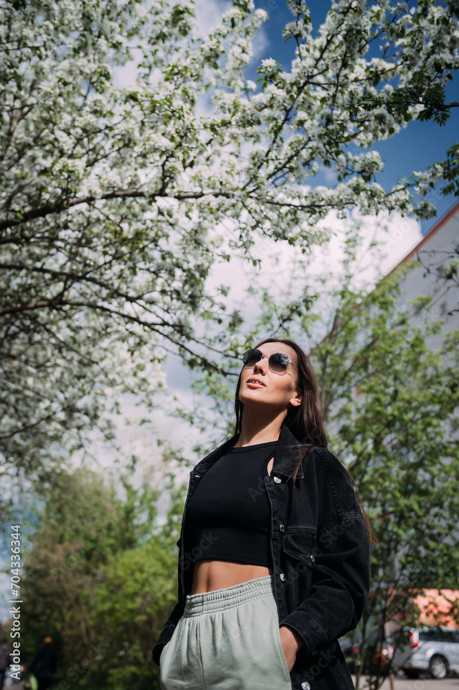 A woman standing under a cherry blossom tree on a sunny day. 4907 A woman standing under a cherry blossom tree on a sunny day. 4907