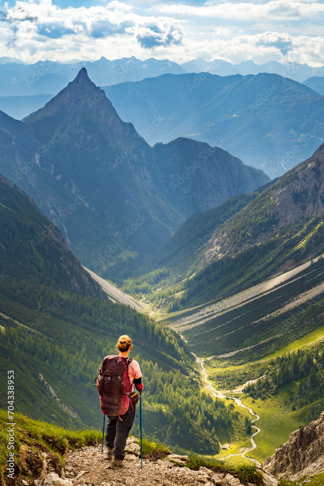 Eine Wanderin bei der Alpenüberquerung blickt auf die Silbersspitze und das Lötzbachtal (Österreich).