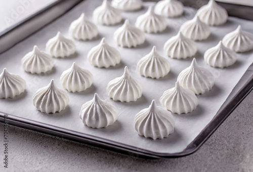 Freshly baked white vanilla Meringue kisses on a tray with baking sheet. photo