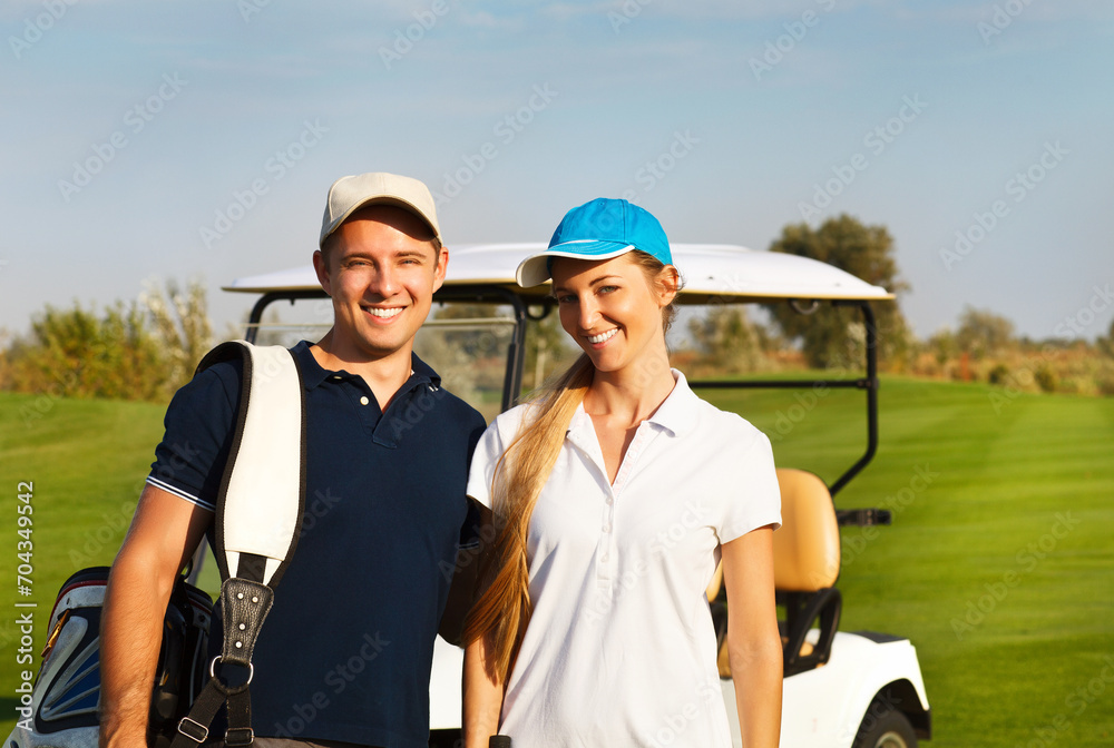 Naklejka premium Young sportive couple playing golf on a golf course
