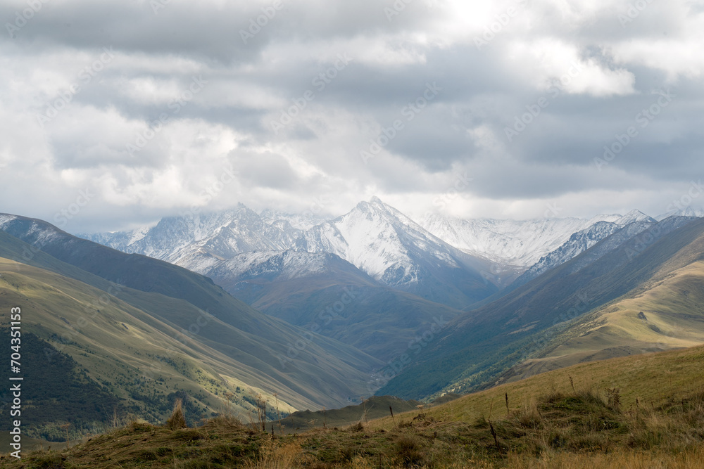 White mountain peaks with low hanging clouds and a beautiful valley