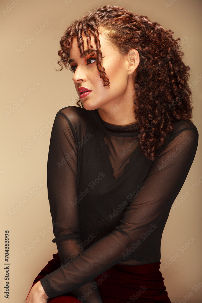 Half-body portrait of a woman seated in profile, with a distant gaze and a beige background Half-body portrait of a woman seated in profile, with a distant gaze and a beige background