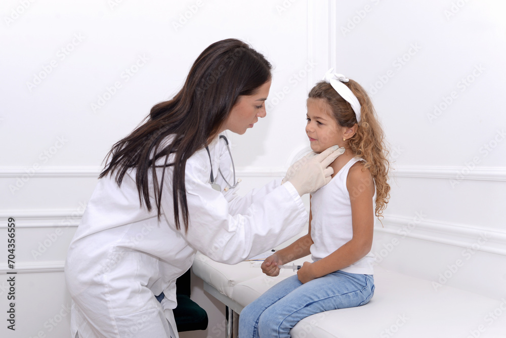 Female doctor smiling and giving medical examination to little girl in clinic Female doctor smiling and giving medical examination to little girl in clinic