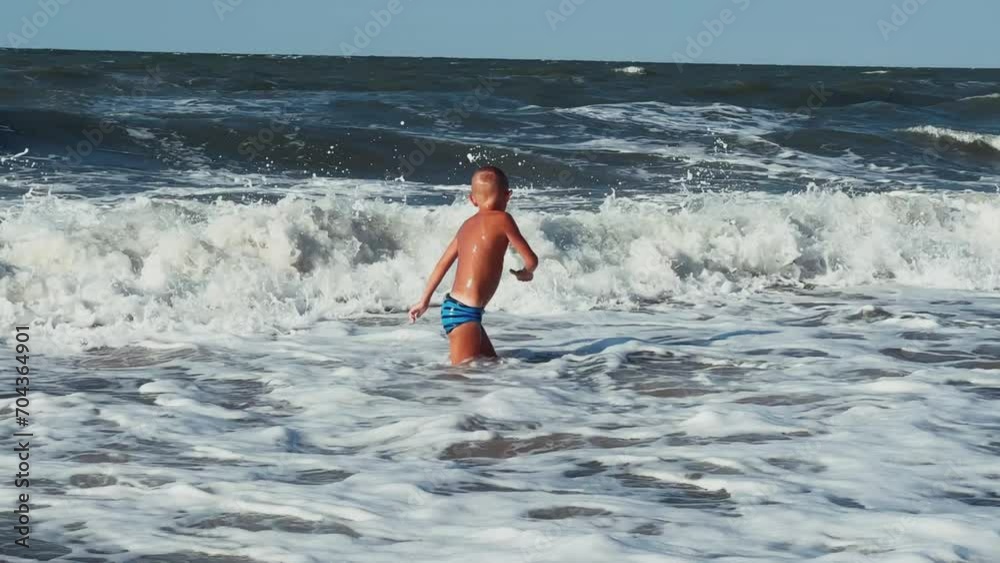 A child swims in the Sea of Azov. A boy jumps into the sea waves from the beach. The boy dives into the foaming wave. The delight of a child from a vacation at the sea. Happy moments with children. 4K A child swims in the Sea of Azov. A boy jumps into the sea waves from the beach. The boy dives into the foaming wave. The delight of a child from a vacation at the sea. Happy moments with children. 4K