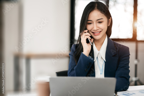 Business women talk mobile phones and working on laptop computers, online business, work from home, teleworking concept.