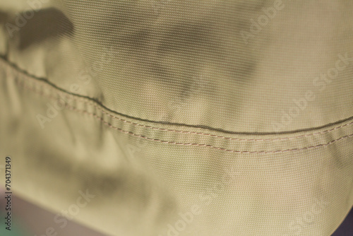 protective work clothes in beige and brown colors. Factory stitches on thick fabric. Close-up texture