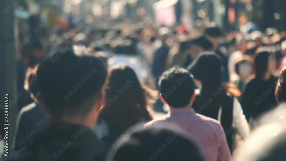 Unfocused blurry crowd of people walking in the street. Slow motion.