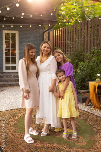 Happy female parent with children, celebration in the garden. © Dasha Petrenko