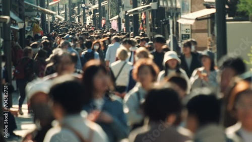Unfocused blurry crowd of people walking in the street. Slow motion.