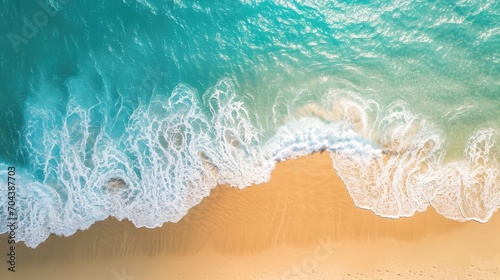Sand beach from above with light blue water wave and sun lights © Ilmi