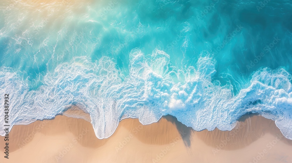 Sand beach from above with light blue water wave and sun lights