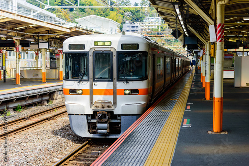 Local train arrive to railway station platform in Japan. Train transportation concept. photo
