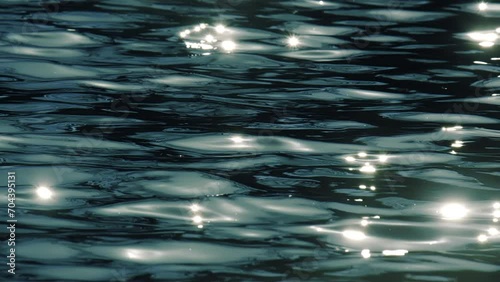 Slow motion of golden glittering sea surface, abstract background.