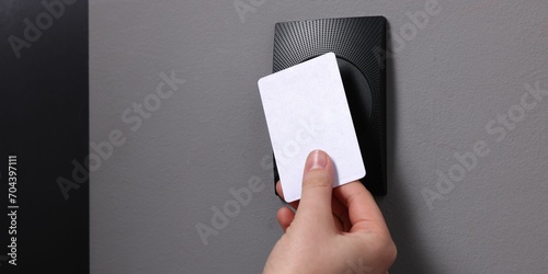 Woman opening magnetic door lock with key card, closeup and space for text. Home security photo