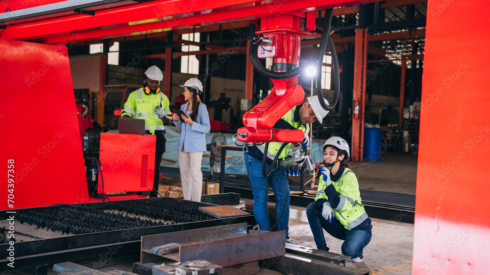 Obraz premium Engineers inspecting and check up machine of the automated arms machine welding robots at factory. Technician controlling the automated arms machine welding robots..